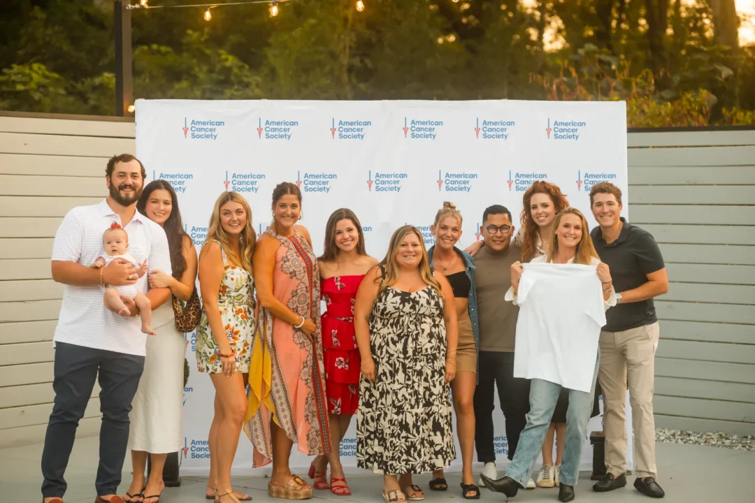 events-3 A group of people posing and smiling in front of an American Cancer Society step and repeat banner.