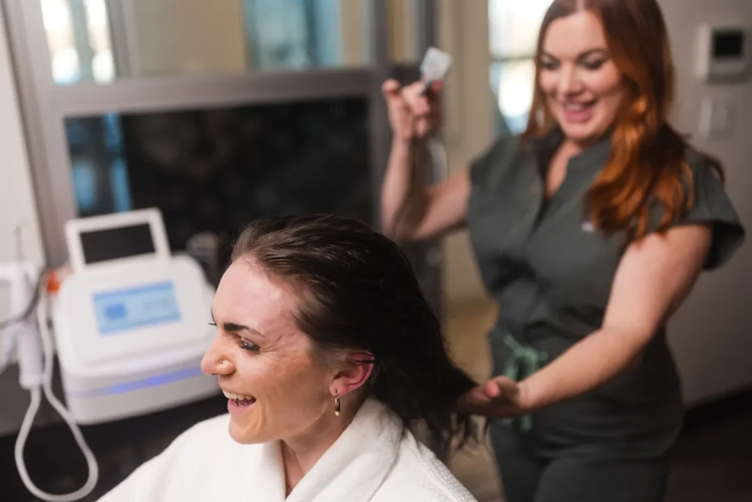 health-wellness-19 Smiling woman gets her wet hair treated by a cheerful stylist in a modern salon setting.
